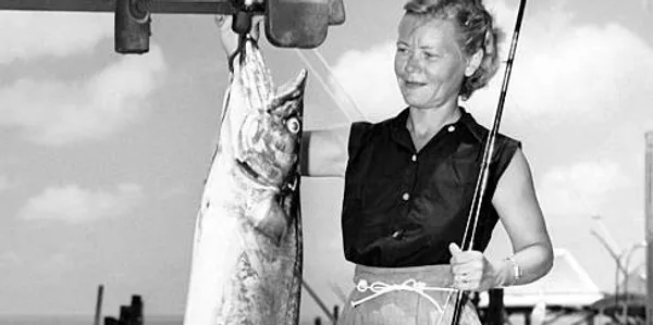 Retro photo of woman holding a large fish.