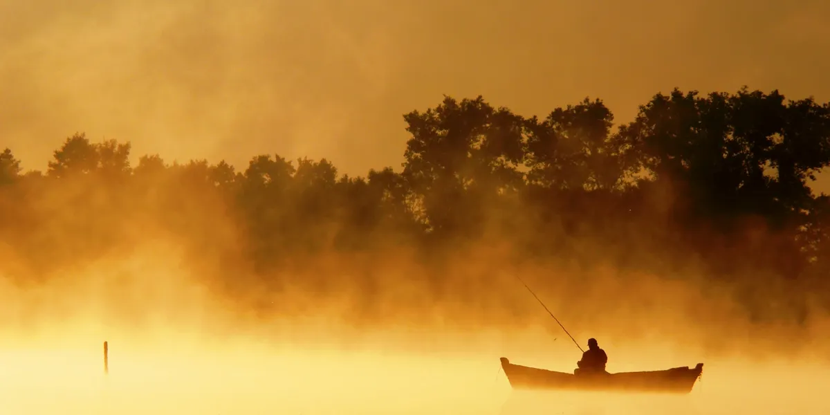 Image of person fishing in the early morning.